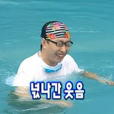 the man is swimming in the water with his headband on and wearing a colorful hat