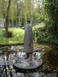 a statue in the middle of a pond surrounded by trees