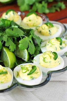 deviled eggs with green peppers and avocado are arranged in a glass dish