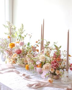 a table with flowers and candles on it