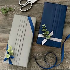 a pair of scissors sitting on top of a wooden table next to a blue book