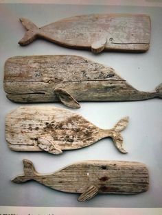 three pieces of driftwood that have been carved to look like whales