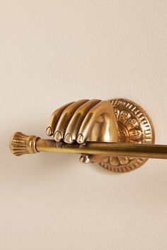 a gold toilet brush is mounted on the wall