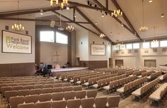 an empty church with rows of chairs in front of the stage and people sitting on the pews