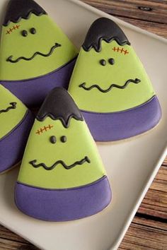 three decorated cookies sitting on top of a white plate