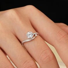 a woman's hand with a diamond ring on top of her finger and an engagement band