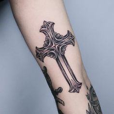 a cross tattoo on the left arm