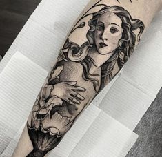 a woman's arm with a black and white tattoo design on the left forearm