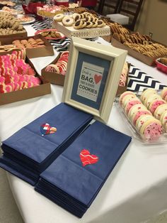 a table filled with cookies and pastries on top of a white table cloth covered table