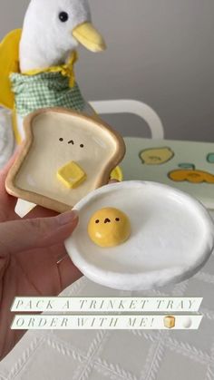 a hand holding a piece of bread with an egg in the shape of a toast