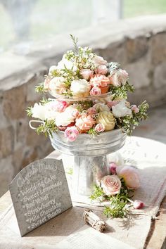 a cake with flowers on top of it sitting on a table next to a sign