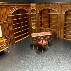 a room with bookshelves, desk and chair in it