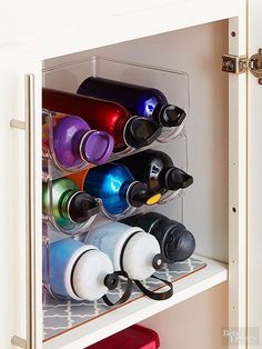 an organized wine rack in the corner of a kitchen cabinet with cups and glasses on it