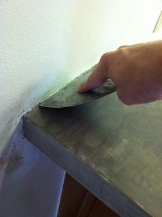 a person is using a knife to cut something on the counter top in order to remove it