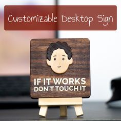 a wooden sign that says, if it works don't touch it on the table