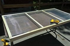 a table that has some yellow tools on it and is sitting in front of a fence