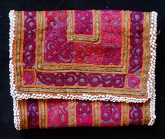 This is a beautiful Pashtun silk embroidered wallet in a wonderful varied hues from the Paktia province, Afghanistan. It is surrounded by blue glass beads. It was also possibly used to hold spices. The workmanship is of very high quality and hand done. It has three compartments. -Mostly natural colors -High quality workmanship Traditional Red Embroidered Clutch, Traditional Embroidered Red Clutch, Traditional Multicolor Embroidered Clutch For Festival, Traditional Handmade Clutch With Multicolor Embroidery, Traditional Embroidered Rectangular Wallets, Embroidered Wallet, Silk Embroidery, Natural Colors, Embroidered Silk