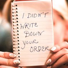 a woman holding a notepad with writing on it that says i didn't write down your order