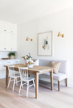 a dining room table with chairs and a bench in front of the kitchen countertop