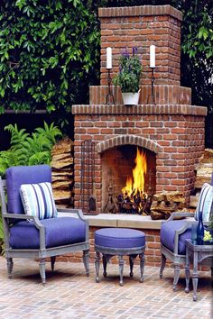 an outdoor fireplace with chairs around it