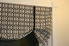 a black and white curtain hanging on the side of a window