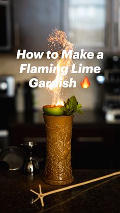 a glass filled with fire next to an apple on top of a kitchen countertop