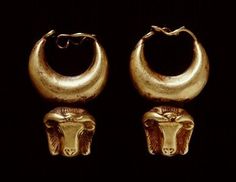 two gold hoop earrings with an animal's head on the front and back of them