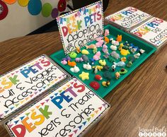 an assortment of plastic toys sitting on top of a table next to cards and markers