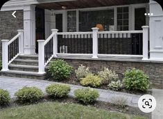 a house with white railings and stone steps