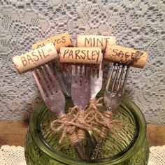 there are four forks in a glass jar with corks on the top and words written on them