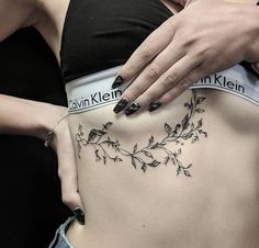 a woman's stomach with flowers on it and a ribbon around her waist that says,