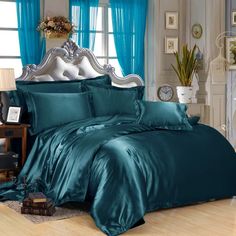 the bed is covered with blue sheets and pillows