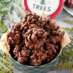 chocolate christmas tree treats in a bowl on a table with pine cones and evergreen branches