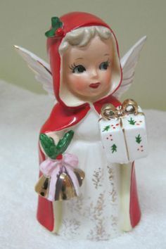 an angel figurine holding a gift box