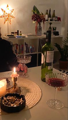 a person sitting at a table with wine and food