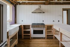 a kitchen with an oven, sink and counter tops in the middle of wood flooring