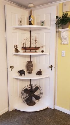 a white shelf with a fan and some figurines on it's sides