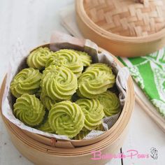 a basket filled with green cookies on top of a table