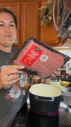 a woman holding a box of ground beef