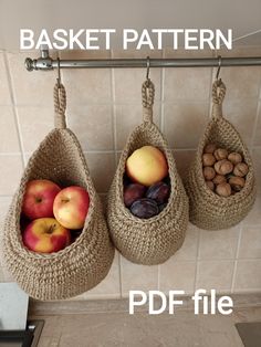 two baskets filled with different types of fruit hanging from hooks on a tiled kitchen wall