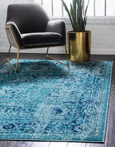 a blue area rug with a chair and potted plant