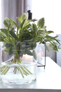 a glass vase filled with flowers on top of a table