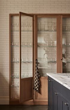 a kitchen with glass shelves and cabinets in it