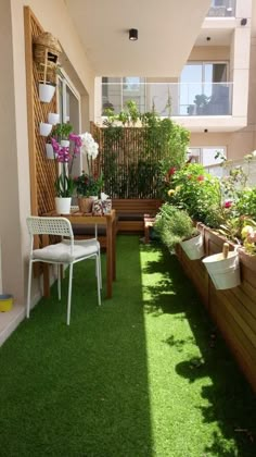 an apartment balcony with artificial grass and potted plants