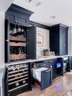 an open cabinet in the middle of a kitchen filled with wine bottles and other items