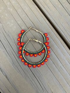 These daisy hoop earrings are so fun! These earrings are made with high-quality toho seed beads. The daisies are red with yellow for the center and a green base. The size of the hoop earrings is 40mm. Daisy Earrings Beads, Adjustable Red Flower Beaded Earrings, Handmade Red Hoop Earrings For Beach, Red Flower Beaded Earrings With Dangling Beads, Red Flower-shaped Jewelry With Dangling Beads, Handmade Red Beaded Hoop Earrings, Perfume Store, Daisy Earrings, Yellow Earrings