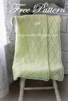 a crocheted blanket sitting on top of a white chair