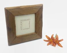 a small wooden frame with a flower in front of it