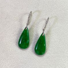 These exquisite teardrop jade earrings feature an 18k white gold setting adorned with scattered diamonds, adding a touch of brilliance. The beautiful combination of the rare jade gemstone and the sparkling diamonds creates a captivating and luxurious design that enhances any outfit. Material: 18k White Gold Gemstone: Natural untreated Type A Burmese Jadeite; Genuine round diamond Jadeite color: Intense Green Total length: 36.2 mm Jade width: 22.2 mm Jade Width 9.9 mm The benefits of natural jade Elegant Jade Teardrop Earrings, Elegant Teardrop Jade Earrings, Teardrop Jade Earrings For Formal Occasions, Elegant Green Teardrop Pendant Earrings, Elegant Teardrop Jade Jewelry, Elegant Jade Drop Jewelry, Elegant Green Hypoallergenic Teardrop Earrings, Cleansing Stones, Jade Gemstone