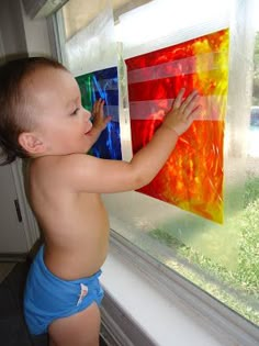 a small child standing in front of a window